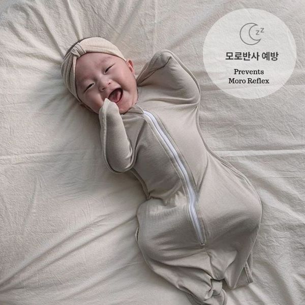 baby in a grey swaddle 