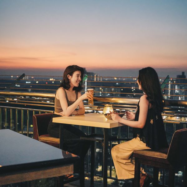 two girls toasting to beer at sky 26 rooftop bar johor bahru