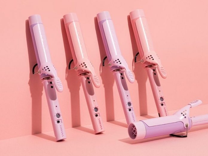 pink hair curling wand against pink background