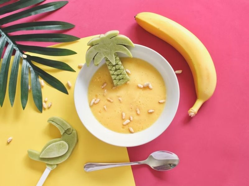 bowl of banana puree with a banana beside it baby food recipes