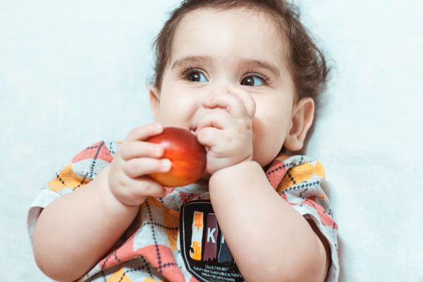 baby holding an apple