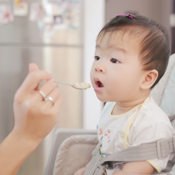 baby opening mouth for an incoming spoon