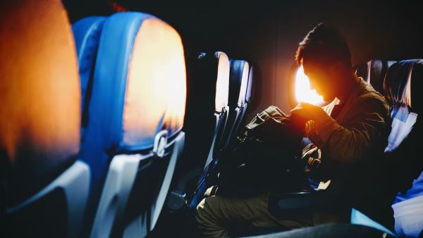 person sitting on a seat on airplane with a backpack