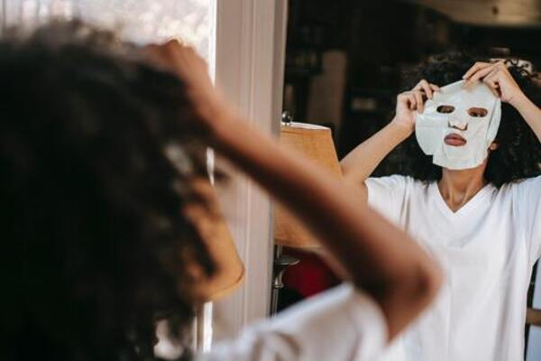 woman putting on best white korean face mask