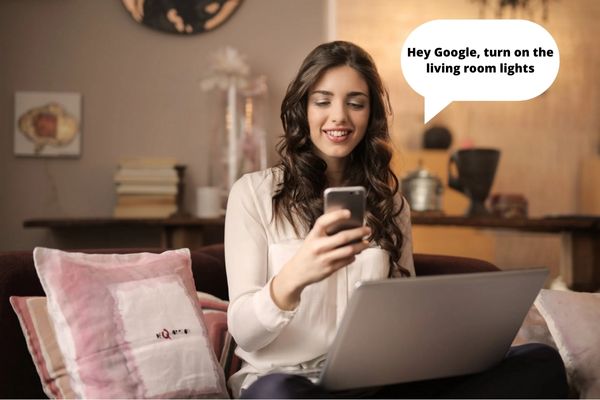 woman looking at phone with laptop on lap