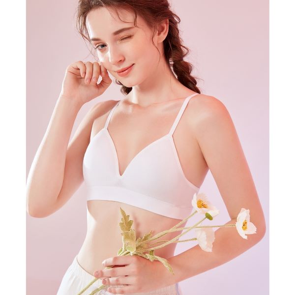 model wearing white young hearts bra and holding flowers while winking