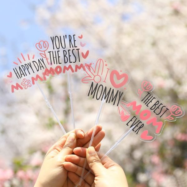 person holding mother's day cake toppers against cherry blossom trees