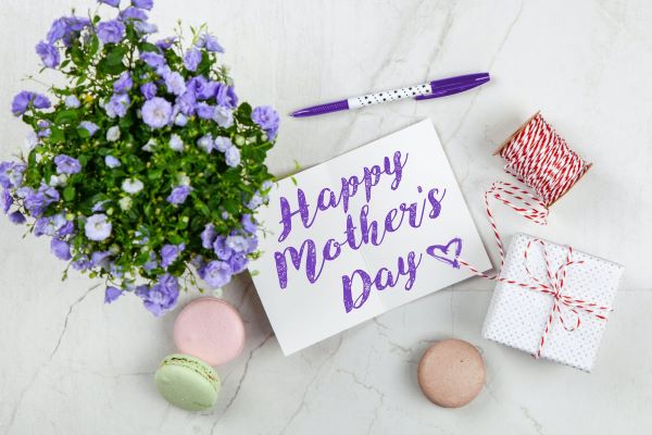 mother's day card with purple calligraphy, flowers, and macarons