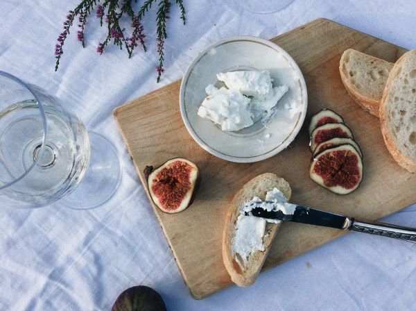 ricotta cheese, bread and fresh figs on a cheese board