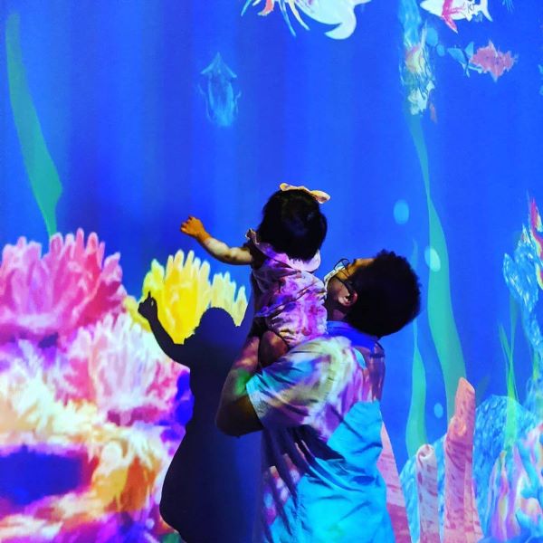 father carrying toddler at artscience museum future world exhibition