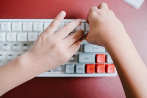 person assembling custom keyboard with white and pink keycaps singapore