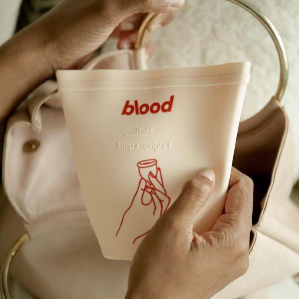 person holding blood menstrual cup pouch
