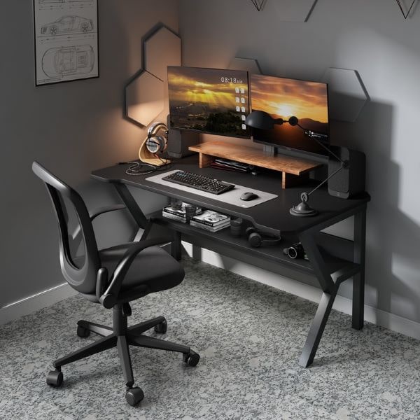 gaming setup with black gaming table, two monitors and black office chair