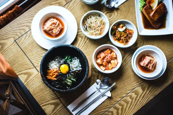 table with a spread of korean food including side dishes and bibimbap