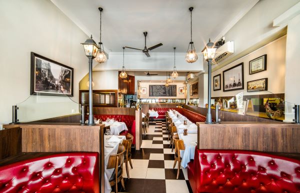 taratata brasserie interior with red cushioned sofas and vintage photographs best french restaurant singapore