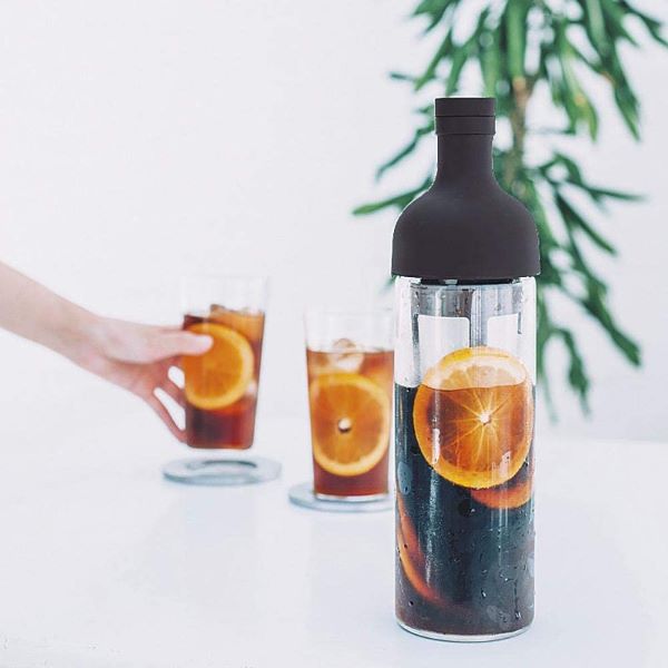filter-in coffee bottle in black with coffee and orange slices inside 
