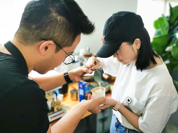 man helping lady with latte art coffee workshops singapore