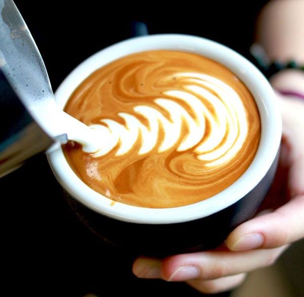 rosetta latte art in black coffee cup