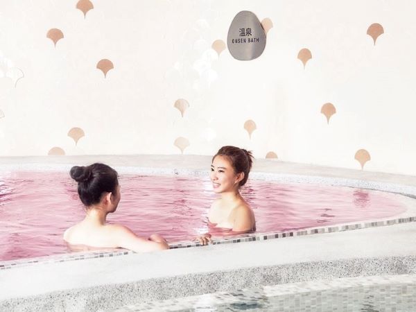 two ladies soaking in a sakura onsen pool at yunomori onsen & spa