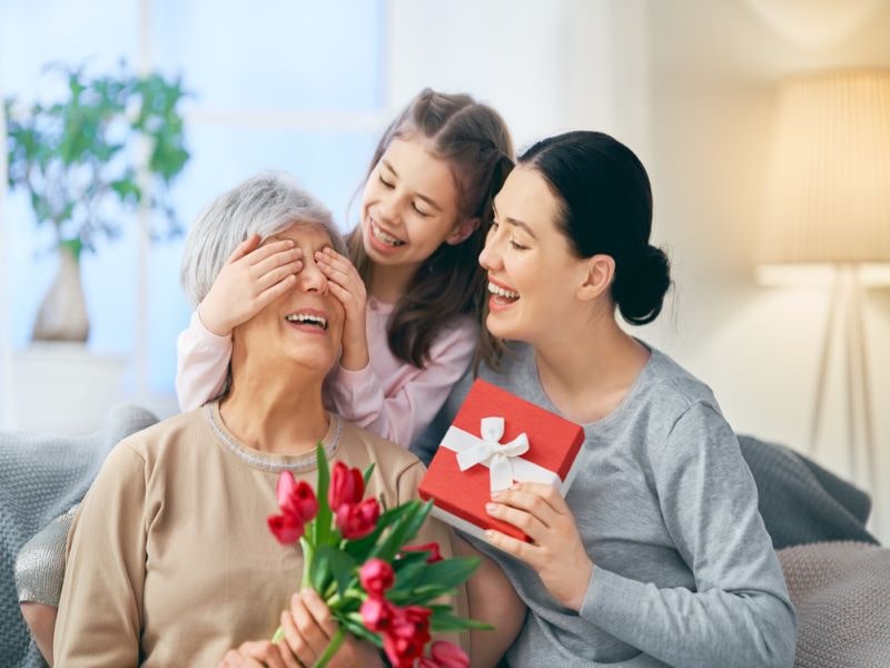 family photo with grandma, mum and daughter giving gifts