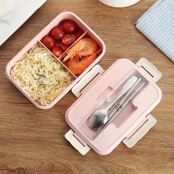pink lunch box with three compartments and utensils in lid