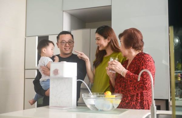 family of four posing next to aox white water dispenser