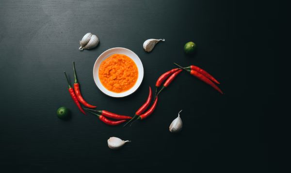 flatlay of chilli sauce, fresh chilli and garlic