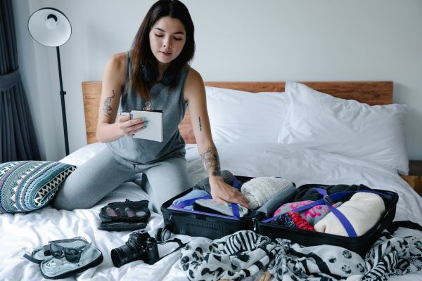 woman packing luggage on bed