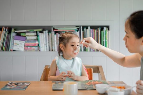 mother feeding food to daughter child food allergy