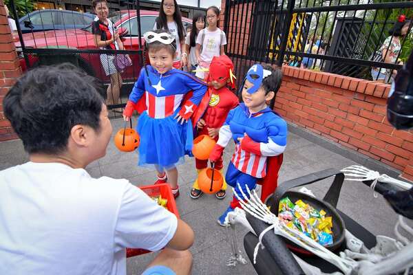 kids in superhero costumes trick or treating at opera estate 