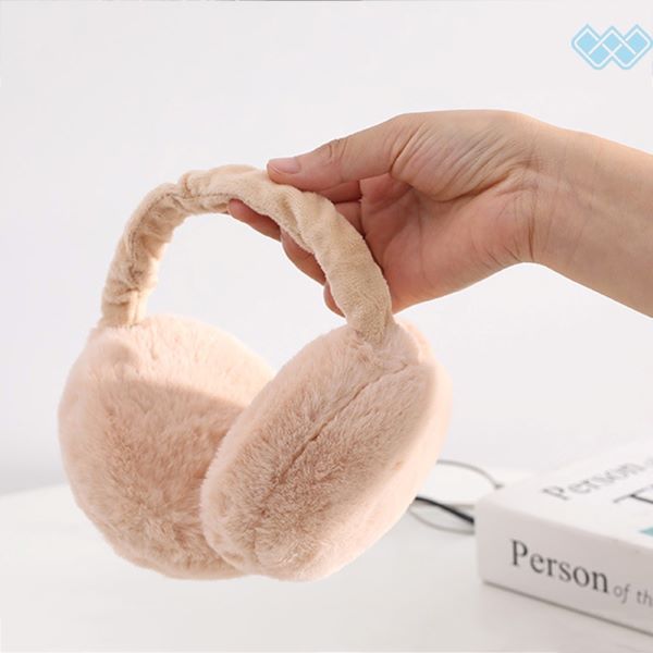 person holding baby pink ear muffs