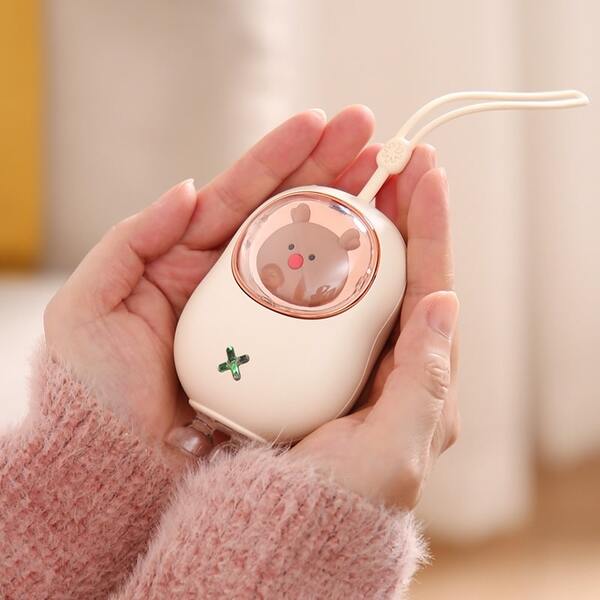person holding pink reindeer rechargeable hand warmer
