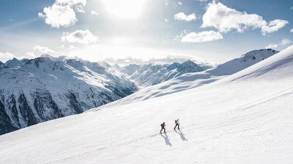 two travellers walking on a snowy mountain