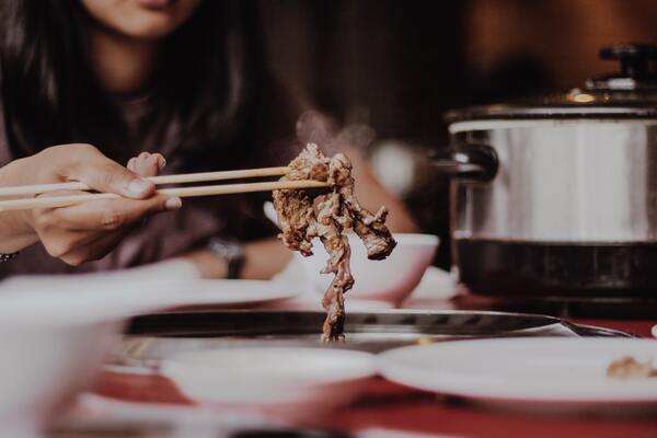 person using chopsticks at the best yakiniku buffet restaurant singapore