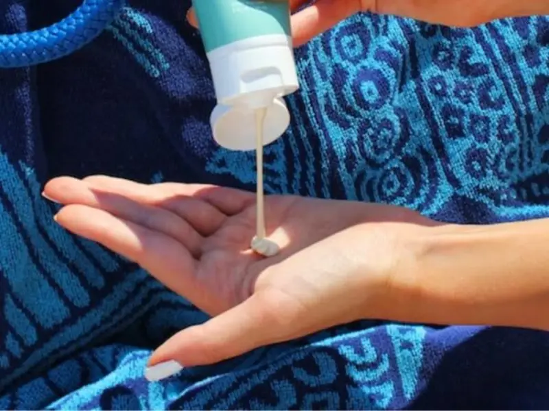 person squeezing sunscreen on palms, best sunscreens for face