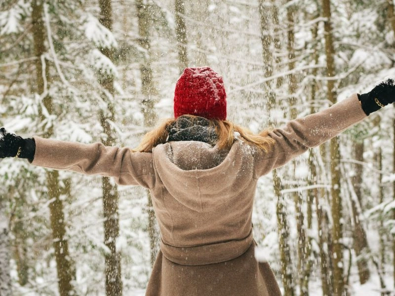 winter packing list: woman enjoying her snowy vacation