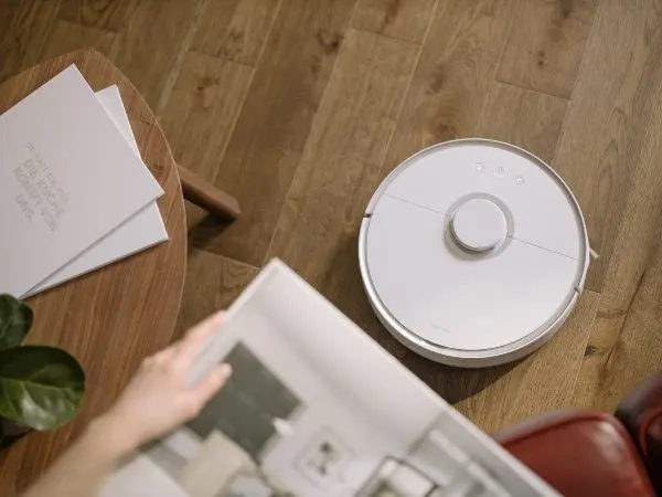 robot vacuum cleaner sweeping across floor while person reads magazine best robot vacuum singapore