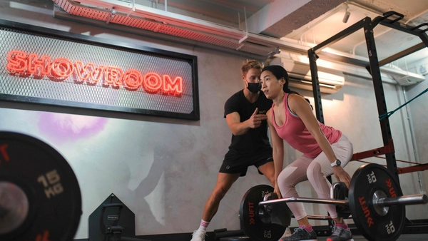 best personal trainer from UFIT Singapore guiding woman to do RDLs