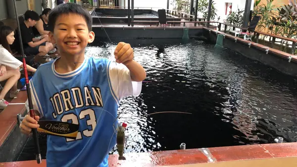 kid catching a prawn at one of the cheapest prawning places in singapore: Bait N Catch