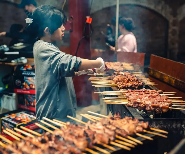grilling meat skewers on the streets
