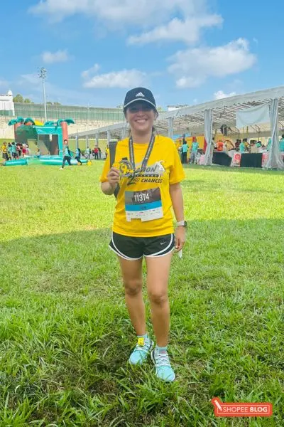Joanna showing her medal as she completes a running event in Singapore